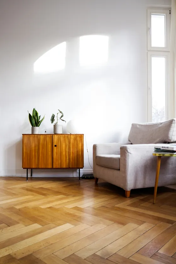 Heller Altbau-Wohnraum mit Fischgrätparkett, Sideboard und hohem Fenster – Substanz und Zuschnitt entscheiden mit über die Vermietbarkeit einer Kapitalanlage