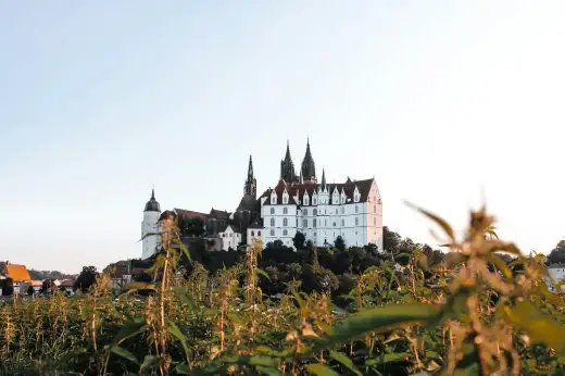 Die weiße Albrechtsburg mit den gotischen Doppeltürmen des Meißner Doms auf dem Burgberg hoch über der Altstadt von Meißen bei Dresden
